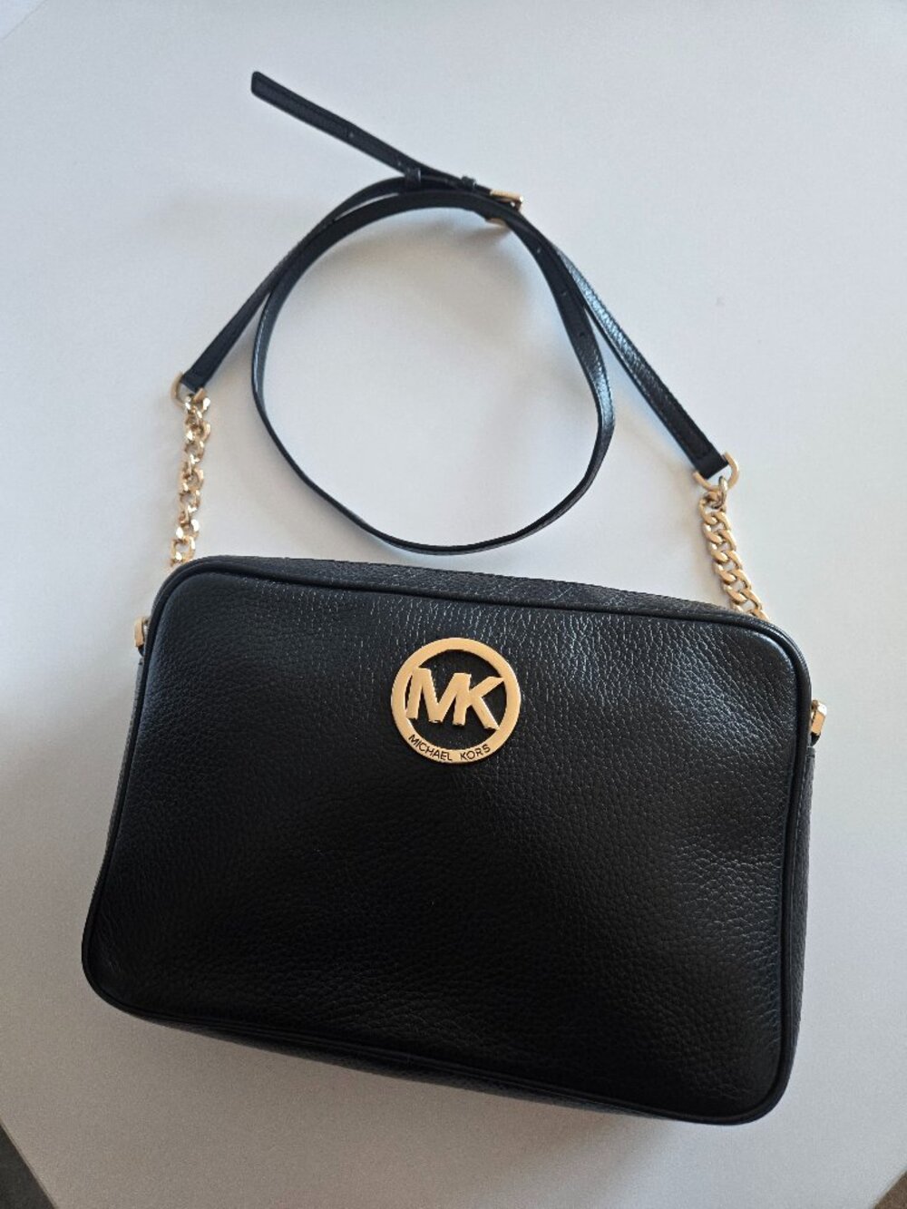 Michael Kors Black pebbled leather crossbody with  a gold-tone circular MK logo